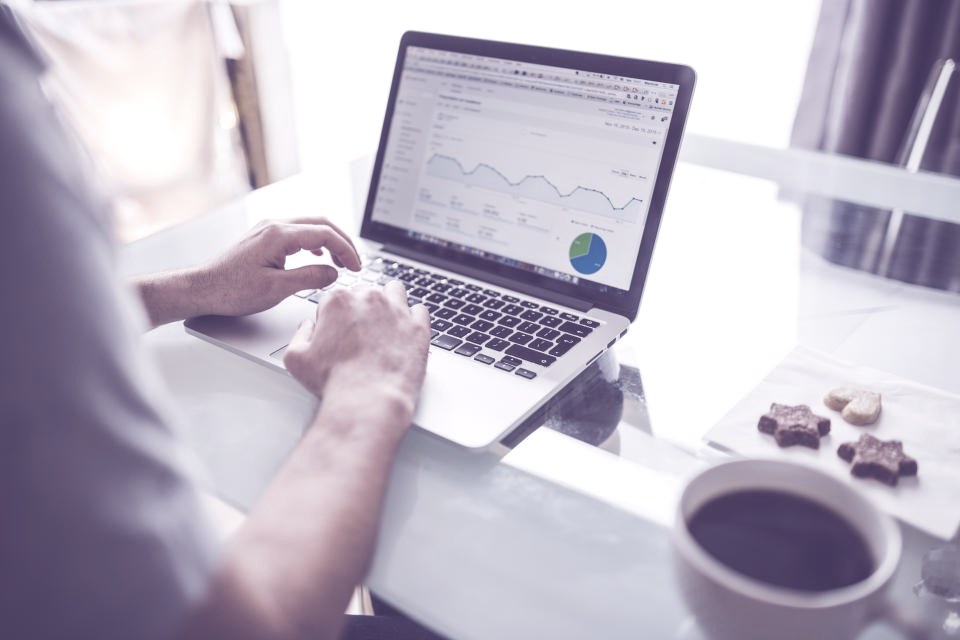 Marketeer analyseert e-mailrapportages en campagneresultaten op een laptop
